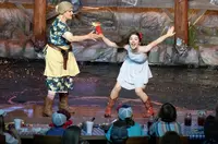 Ma Hatfield holding firework with young girl during the show